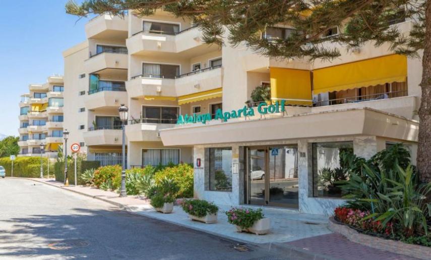 um edifício com um sinal na lateral em Habitación deluxe con baño privado en Atalaya Apartagolf, Estepona em Estepona