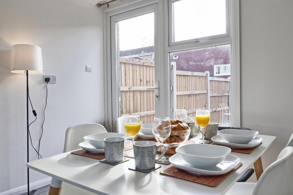 Newly Refurbished 3BR House Basildon, Garden, Netflix & Trisport Table في Nevendon: طاولة غرفة طعام بيضاء مع طاولة طعام بيضاء