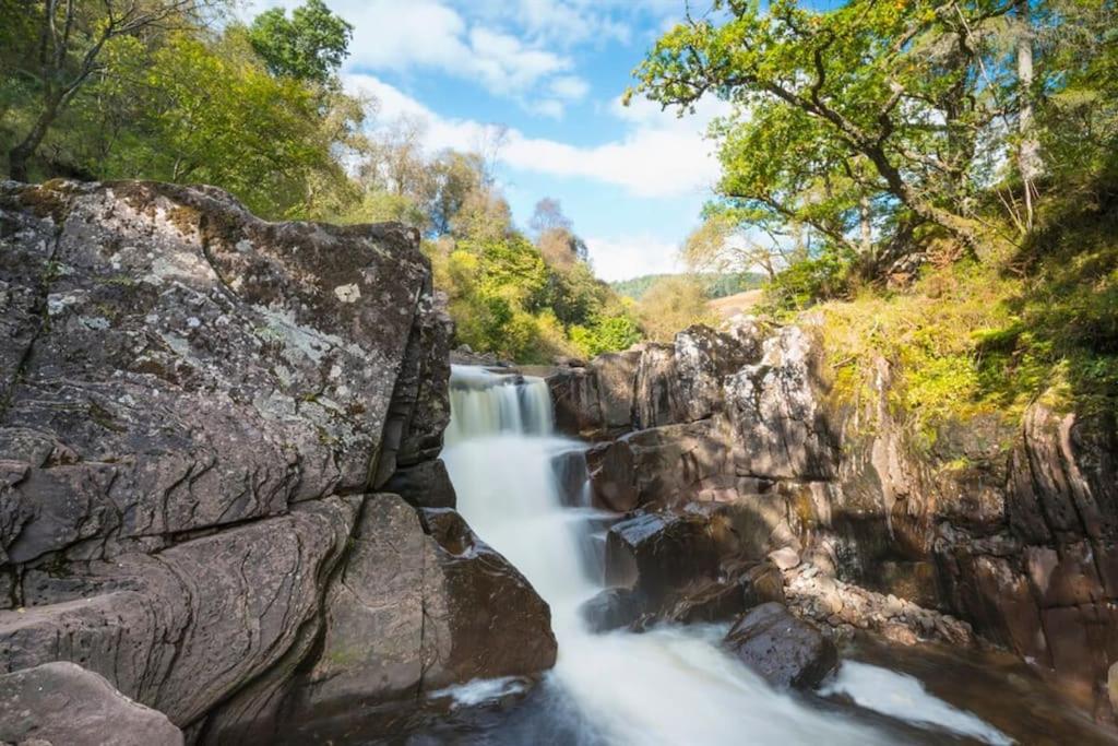 a waterfall on a river in a forest at Newly refurbished flat - Callander in Callander