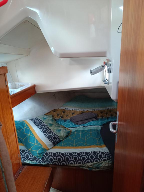 a small room with a bed in a boat at cabine sur bateau à quai in Le Marin