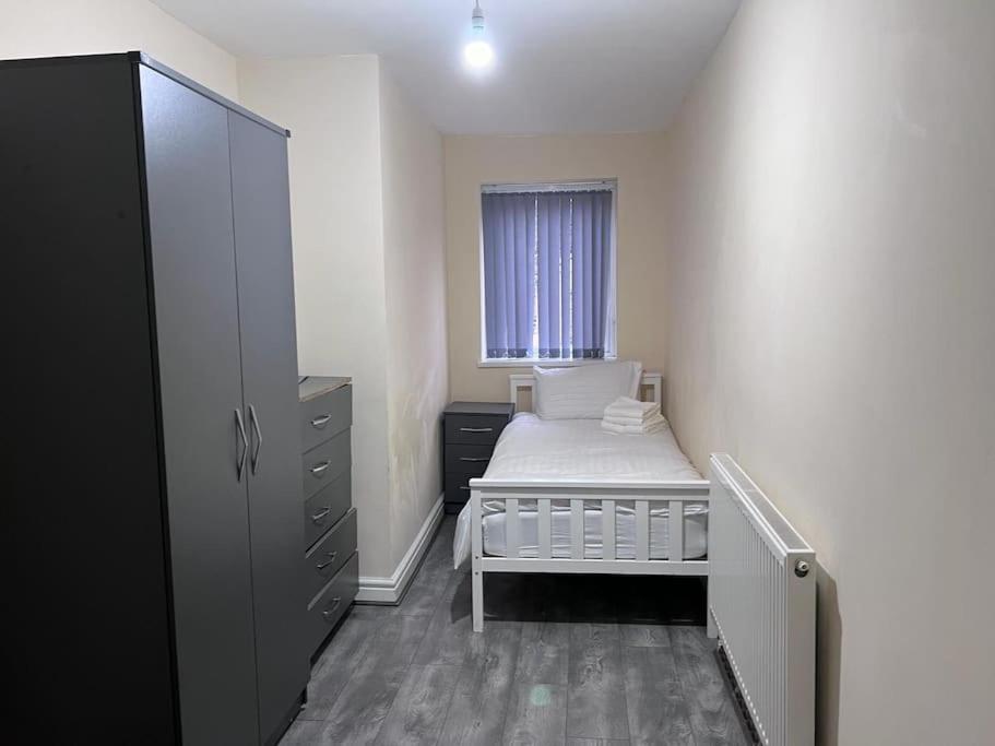 a small bedroom with a bed and a window at Luxury 2 Bed Apartment in Manchester in Manchester