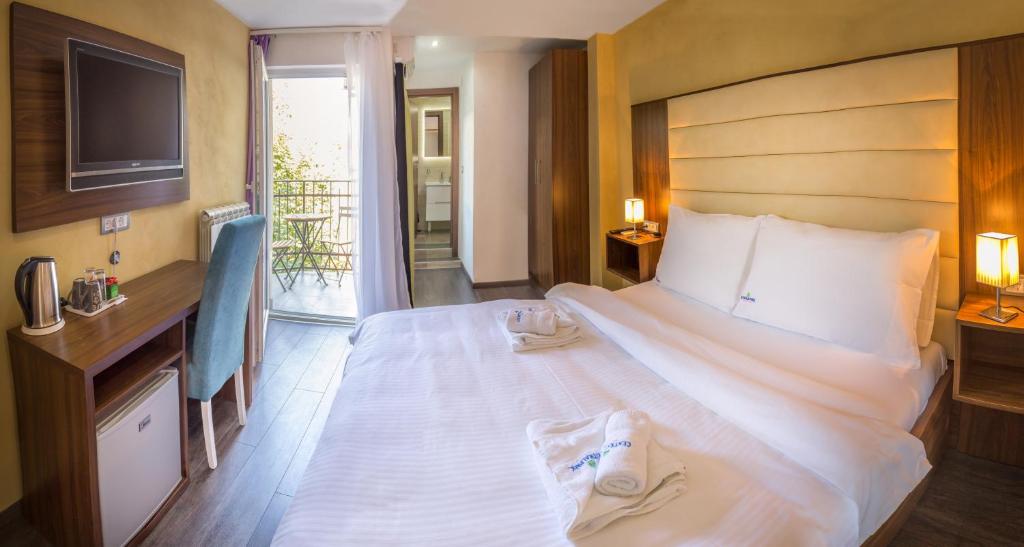 a bedroom with a large white bed with shoes on it at Central Park Residence in Belgrade