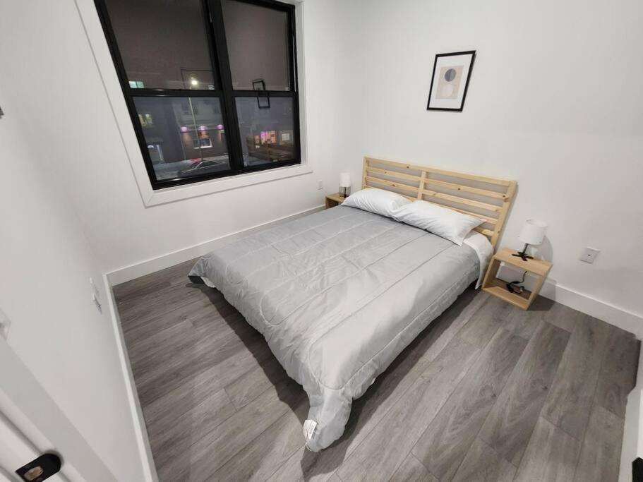 Schlafzimmer mit einem großen Bett und einem Fenster in der Unterkunft Vast Fully Furnished 2-Bed Close to NYC in Bayonne