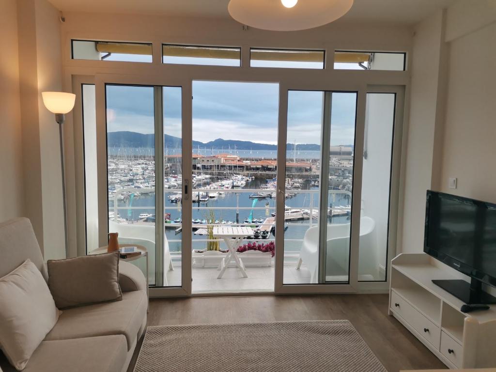 Una sala de estar con vista a un puerto deportivo. en Balcón al Mar, en Sanxenxo