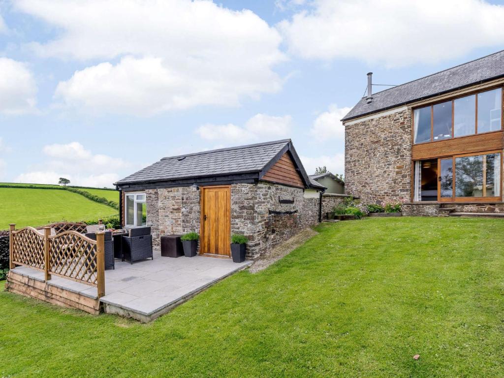 an exterior view of a stone house with a patio at 2 Bed in Umberleigh 74967 in Chittlehampton