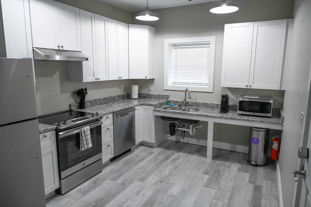 a kitchen with white cabinets and stainless steel appliances at The Borden Room in Biloxi