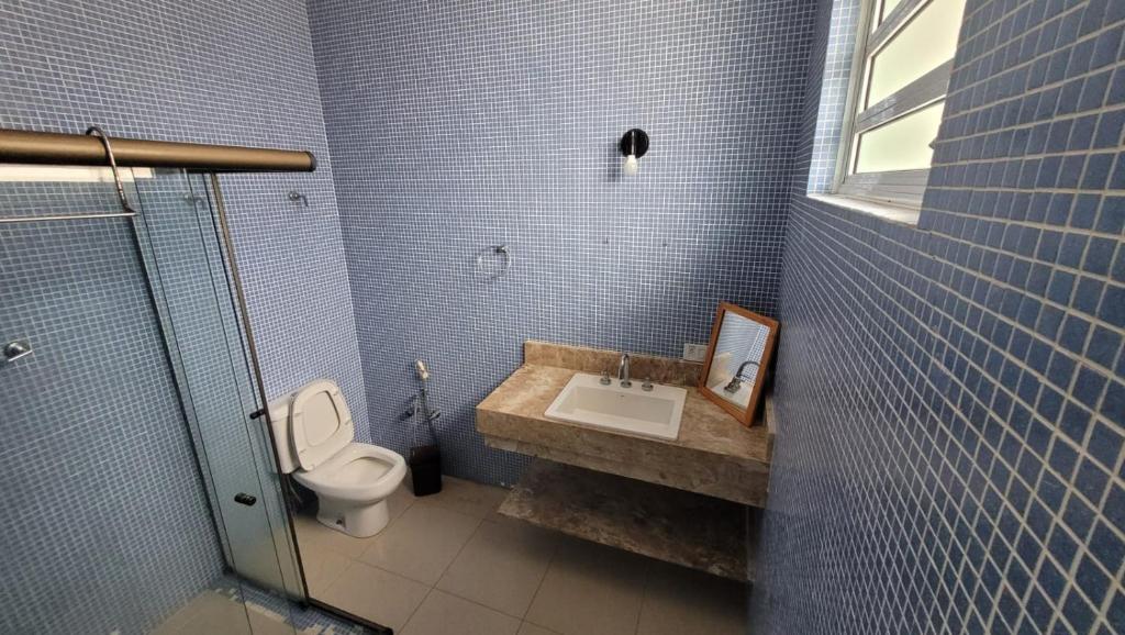 a bathroom with a sink and a toilet at Casa Praia dos Sonhos in Itanhaém