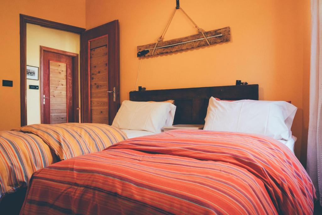 a bedroom with two beds with orange walls at B&B del Villaggio in Argentera