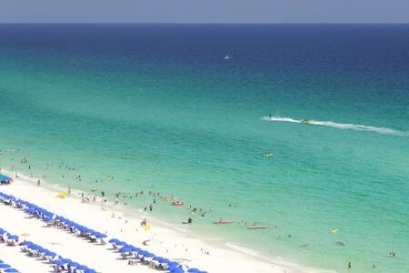 a group of people on a beach in the ocean at The Scallop by Brightwild-Beachfront Condo in Destin