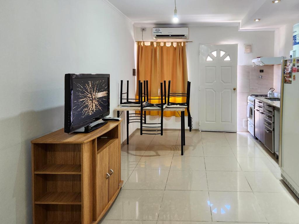 sala de estar con TV en un soporte de madera en Departamentos Segovia., en San Rafael