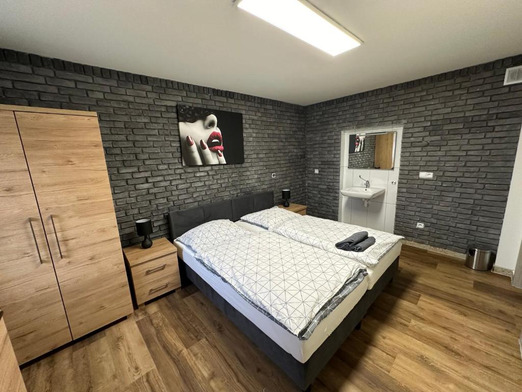 1 dormitorio con cama y pared de ladrillo en Dom Gościnny Gerus en Pławna