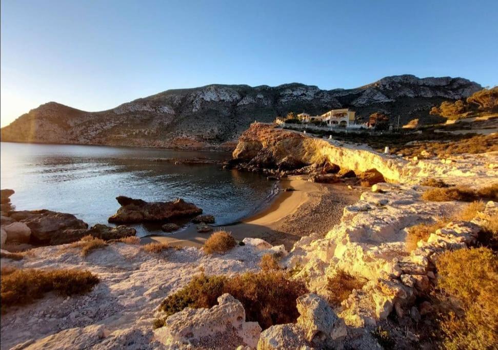 a beach with rocks and a body of water at Villa Del Cabo in Águilas