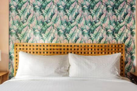 キーウェストにあるGreen Room at the Grand Maloneyの花柄のヘッドボードと枕2つが備わるベッド1台