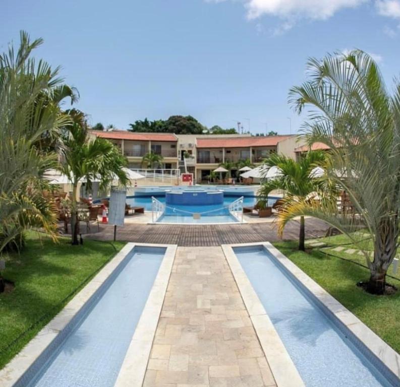 un complejo con 2 piscinas y palmeras en Flat todo ambientado no coração de Pipa - Solar Água Apart Hotel, en Pipa