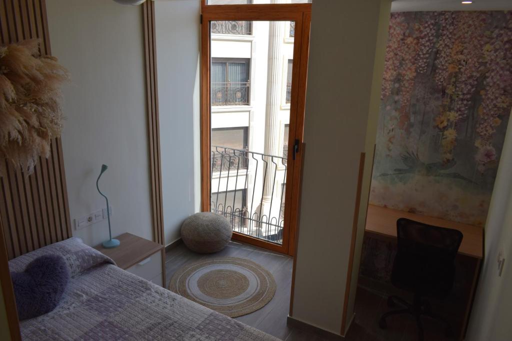 a bedroom with a bed and a window with a balcony at Apartamento Ladevesa in Elche