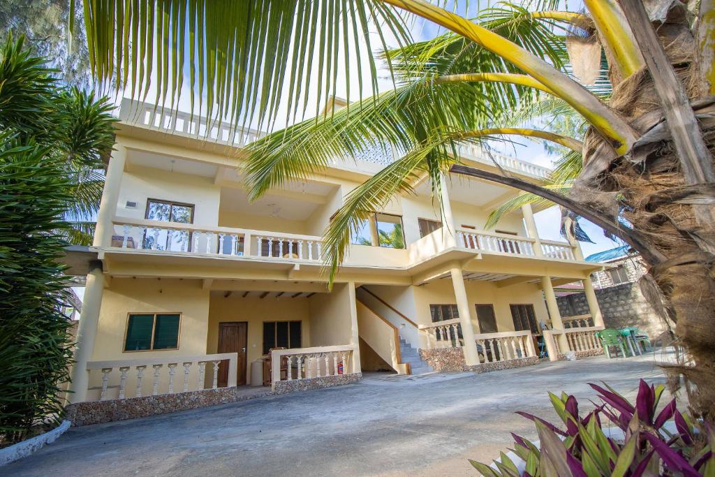 una casa con una palmera delante de ella en Watamu GK Palms en Watamu