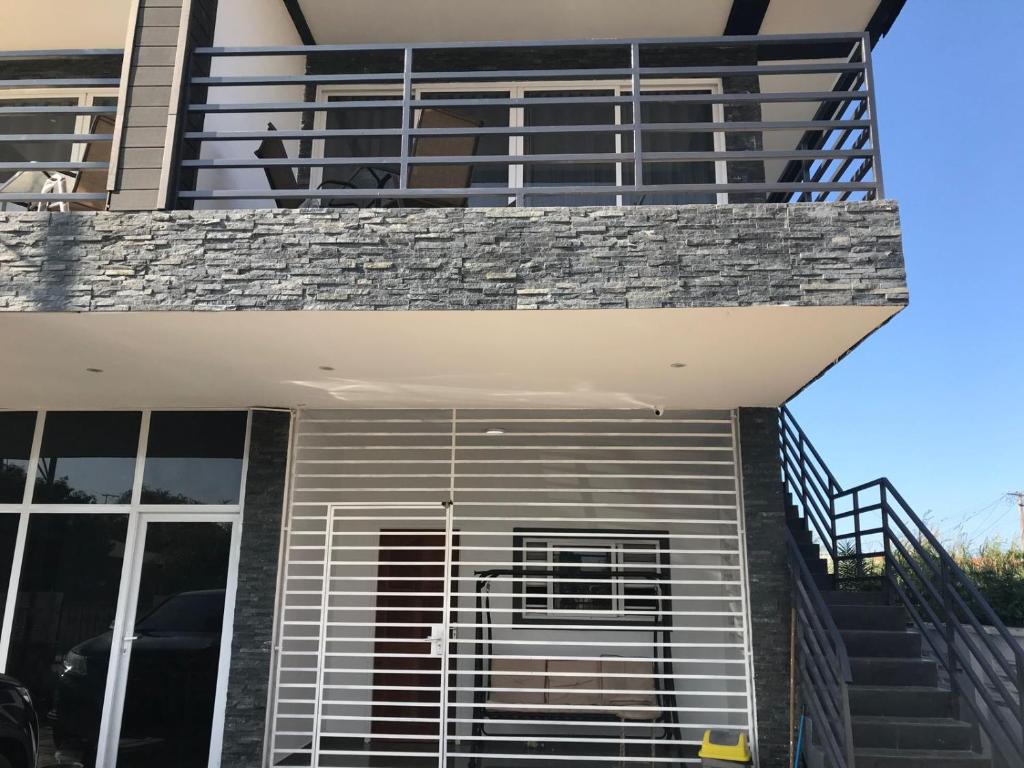 een balkon van een huis met een trap en een leuning bij Kapowlito Real Estate Casa Cocobiacoweg in Paramaribo