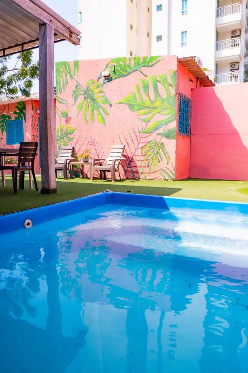 a swimming pool in front of a wall with a mural at Hotel Casamart Rodadero in Santa Marta