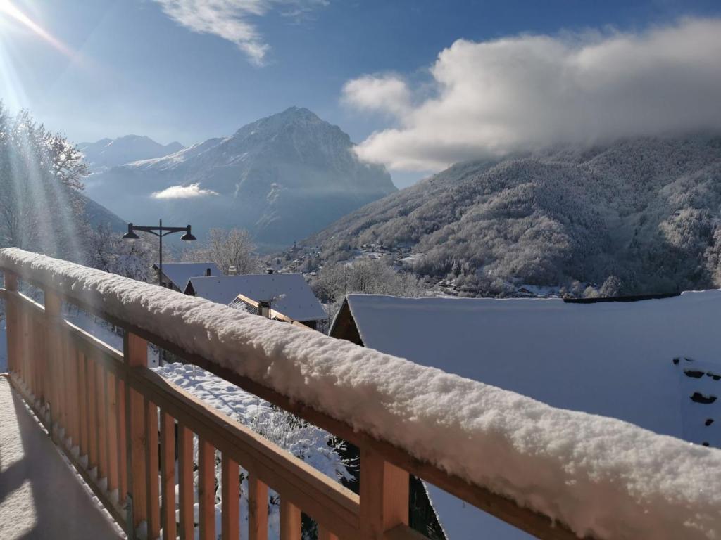 a snow covered balcony with a view of a mountain at Chalet Coté Cour à 10 min de la Station in Oz