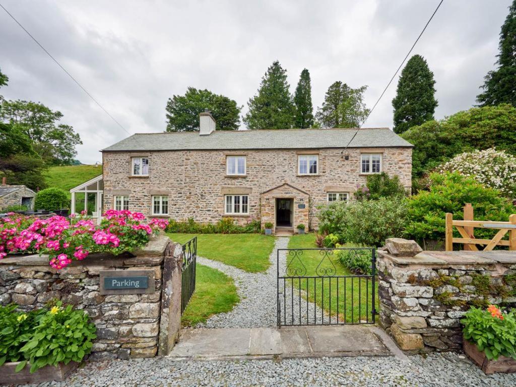 an old stone house with a gate and flowers at 4 Bed in Sedbergh SZ595 in Milnthorpe