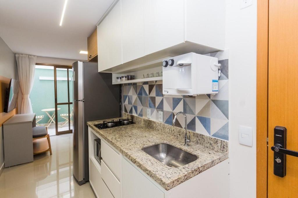 una cocina con fregadero y microondas en Noroeste 10/11 Square, en Brasilia