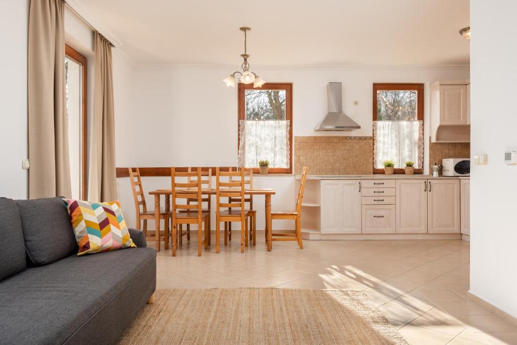 cocina y sala de estar con mesa y sillas en Zala Hills Apartman - Batthyány Villapark, en Zalacsány