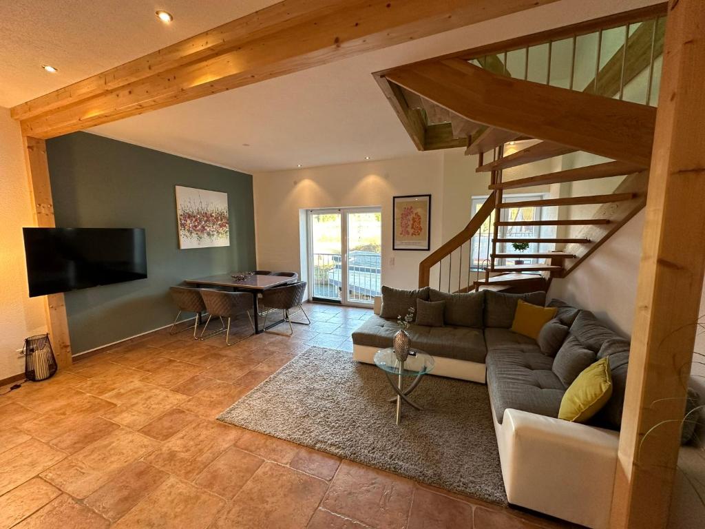 ein Wohnzimmer mit einem Sofa und einem TV in der Unterkunft FEWO Sternen Plus in Donaueschingen