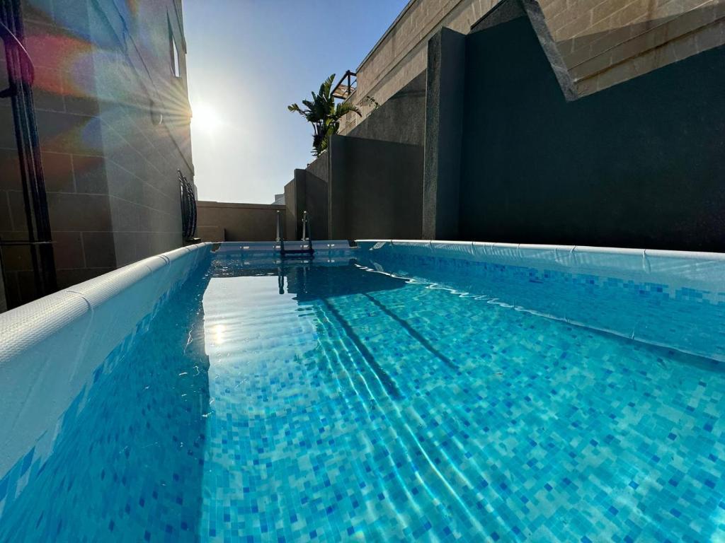 a swimming pool with blue water in a building at BaySide1 Marsaxlokk Malta in Marsaxlokk