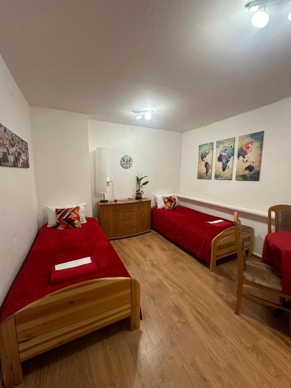a bedroom with two beds and a red blanket at Travel House Wrocław in Wrocław