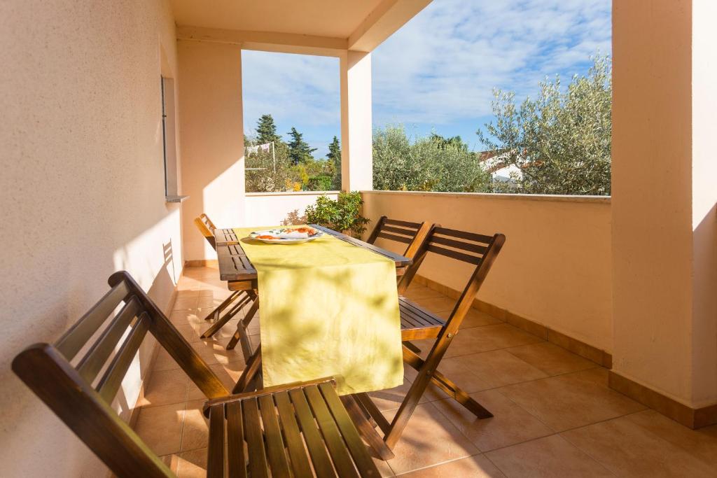 a table and chairs on a balcony with a window at Spacious and bright apartment- Silvio 1 in Banjole