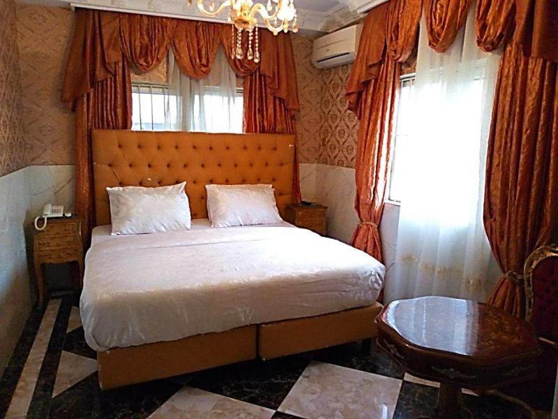 a bedroom with a large bed and a window at Grand Emperor Museum Hotels and Resorts in Lekki