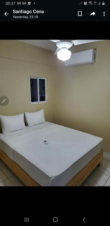 um quarto com uma grande cama branca num quarto em July Vladimir em San Felipe de Puerto Plata