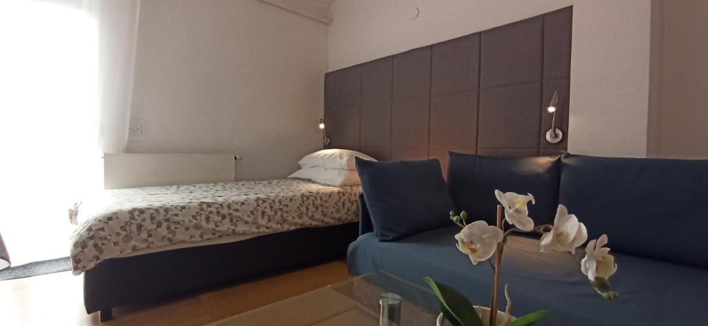 een slaapkamer met een bed en een bank met witte bloemen bij OK studio & rooms Lipik in Lipik