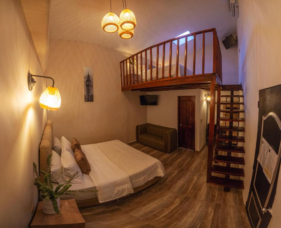a bedroom with a bed and a spiral staircase at HOTEL BALI AT POBLADO in Medellín