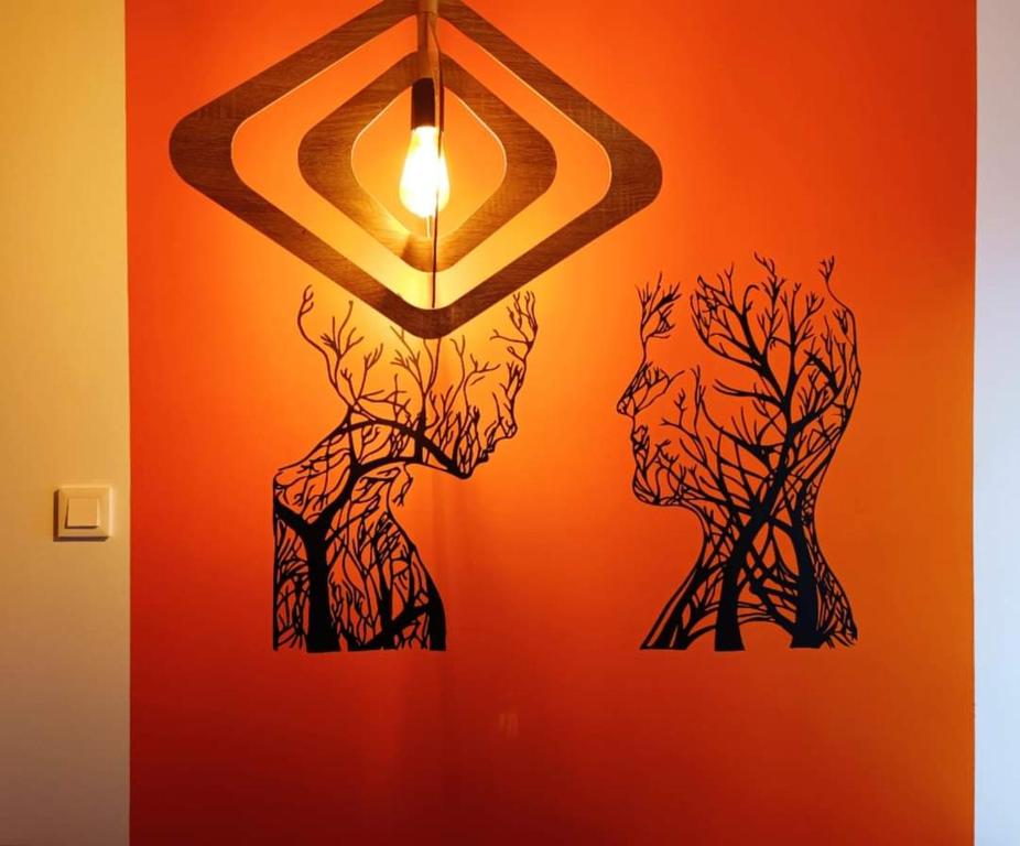 Una pared con una lámpara y árboles. en Apartament Aleksandra, en Tolkmicko