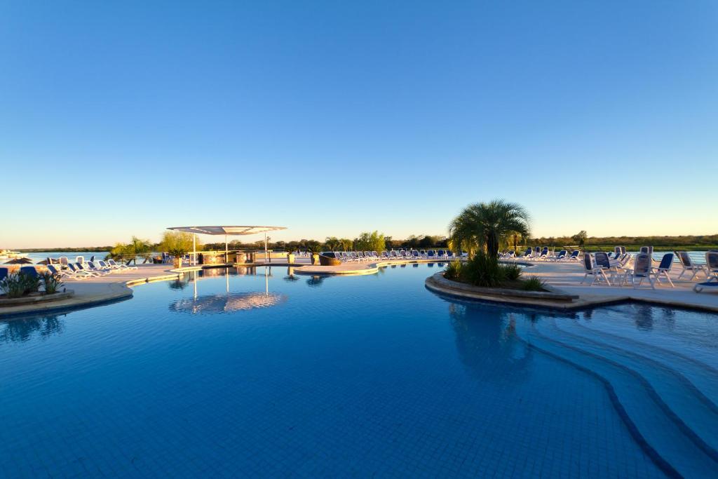 uma grande piscina com cadeiras e um resort em Resort Yacht Y Golf Club Paraguayo em Assunção