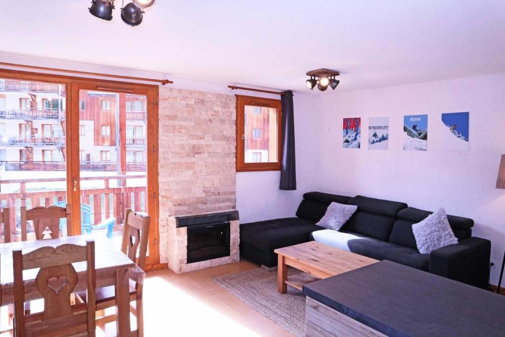 ein Wohnzimmer mit einem Sofa und einem Tisch in der Unterkunft Résidence Parc Des Airelles - 2 Pièces pour 8 Personnes 251 in Les Orres