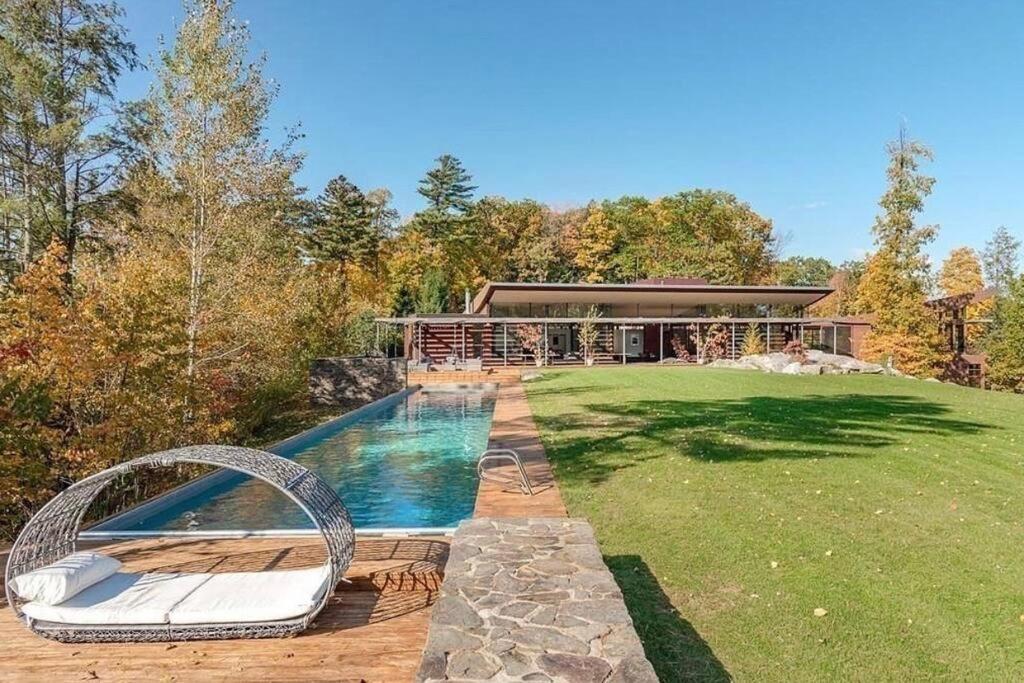 a backyard with a pool and a house at Magical Country Retreat in the Berkshires in Great Barrington