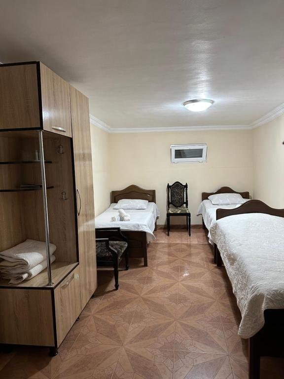 a room with two beds and a cabinet in it at Linda Guest house in Batumi