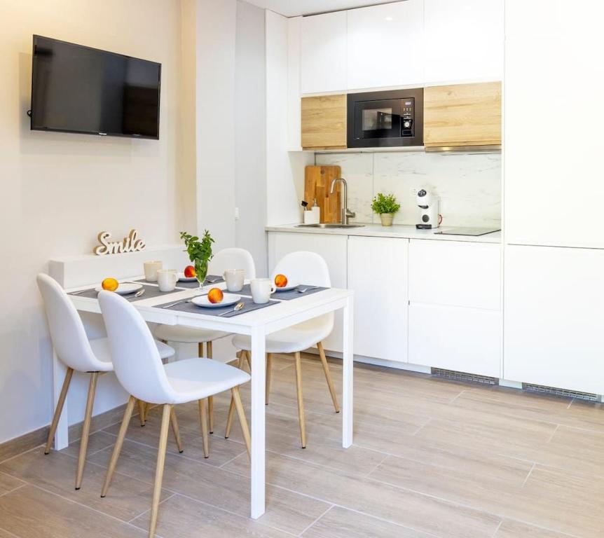 un comedor blanco con una mesa y sillas blancas en Precioso apartamento con Jardín a 500m de la Playa en Altafulla