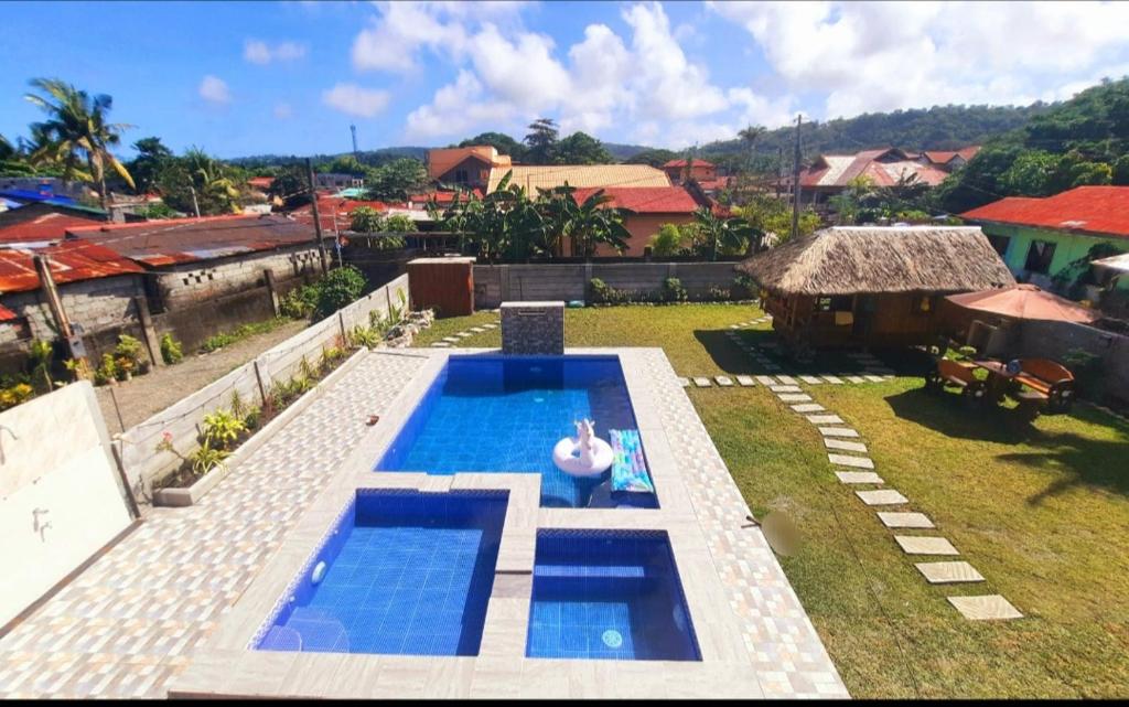 um quintal com uma piscina e uma casa em LS Resthouse with pool and garden em Calapan
