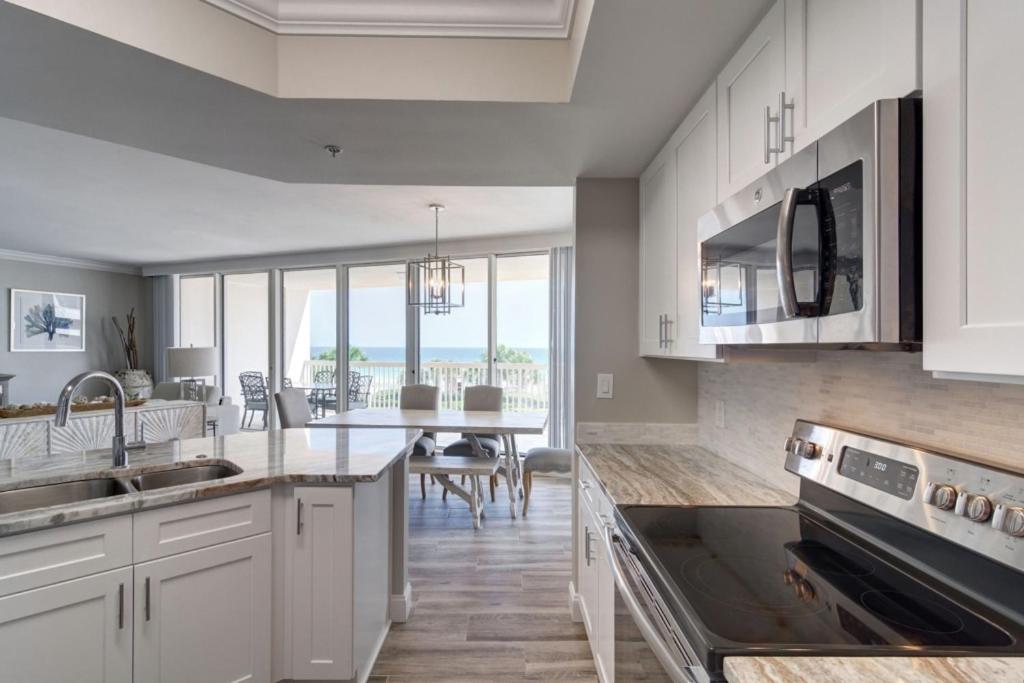 a kitchen with white cabinets and a view of the ocean at St Maarten 308 a Renovated Luxury Beach Front 3 Bedroom 3rd Floor Condo with Resort Amenities in Destin