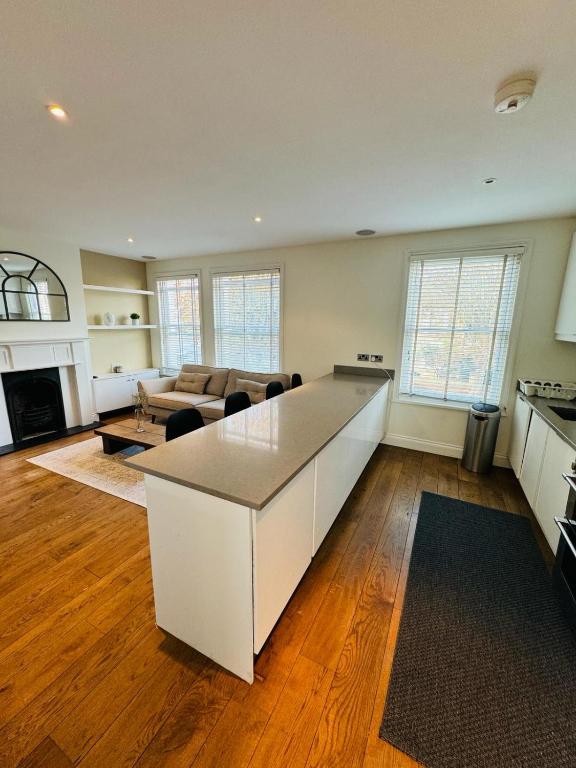 eine Küche und ein Wohnzimmer mit einer großen Insel in der Mitte in der Unterkunft Stunning Flat in Chiswick in London