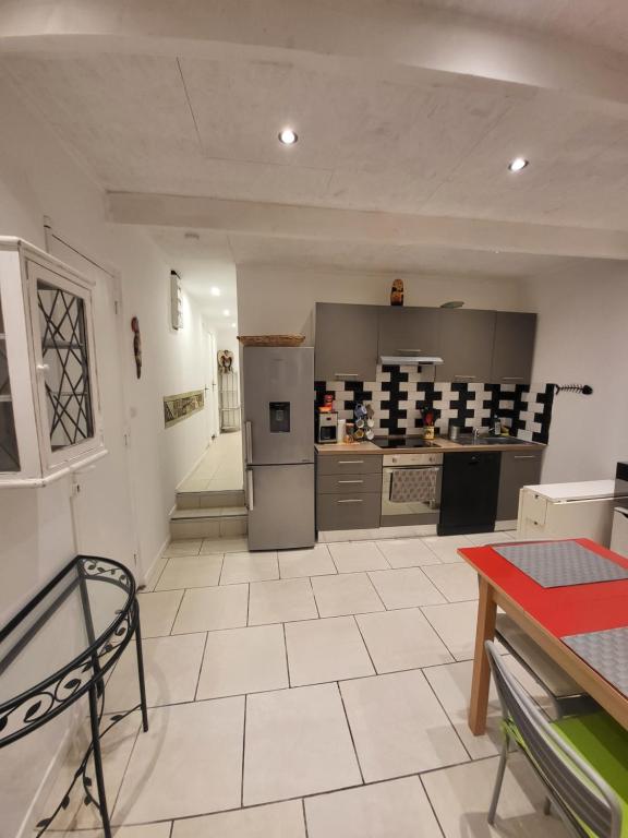 uma grande cozinha com uma mesa e um balcão em Appart spacieux à 2 pas du port em La Ciotat