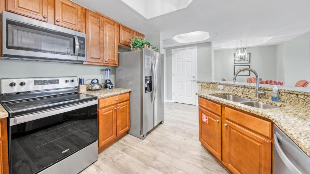 eine Küche mit Holzschränken und einem Edelstahlkühlschrank in der Unterkunft St Lucia 1204 a Luxury Condo with Gulf Views in Destin