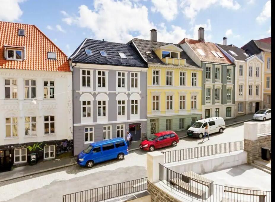 un groupe de bâtiments avec des voitures garées dans un parking dans l'établissement Fin og super sentral leilighet, à Bergen