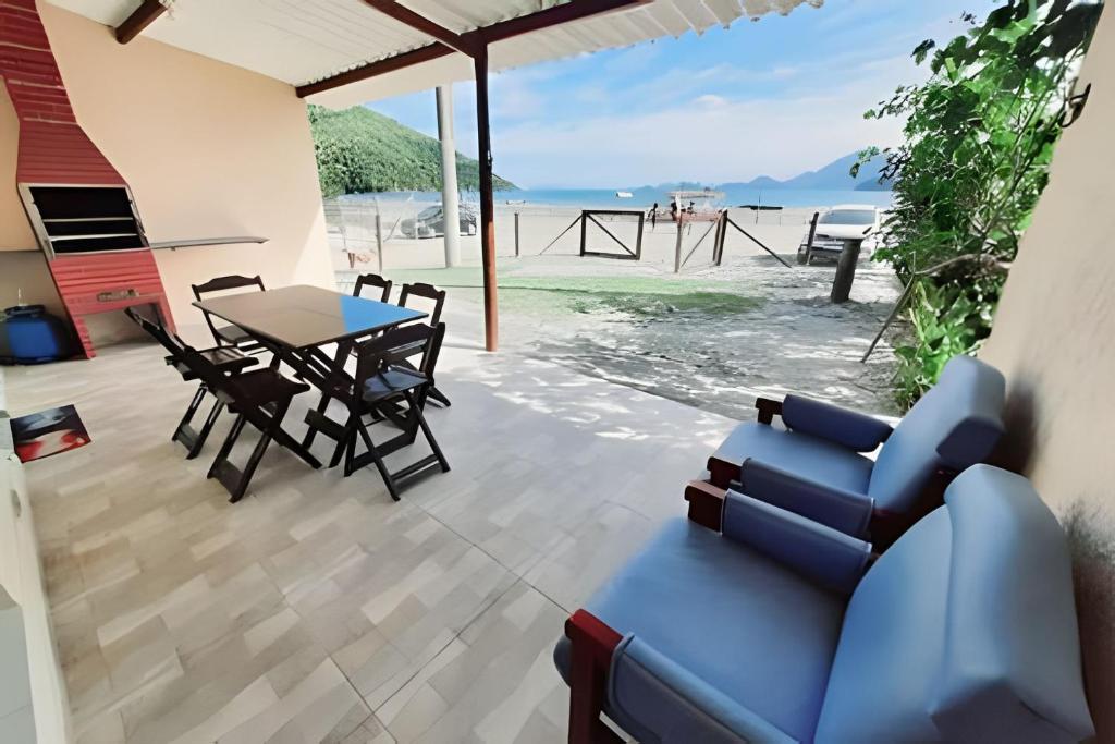 Frente ao mar casa 42 Praia do Estaleiro في أوباتوبا: غرفة معيشة مع أريكة زرقاء وطاولة
