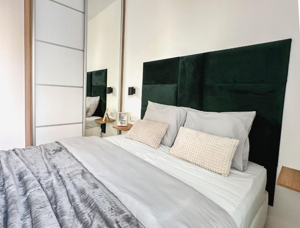 a bedroom with a large bed with two pillows at Wygodne Mieszkania Nova Mikołowska 123 in Katowice