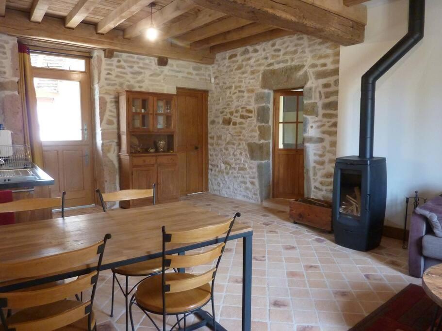 a living room with a wooden table and a wood stove at Le Cercotin in Moroges
