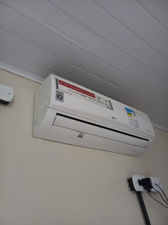 um ar condicionado branco pendurado no tecto em Condomínio Village Paraty em Paraty